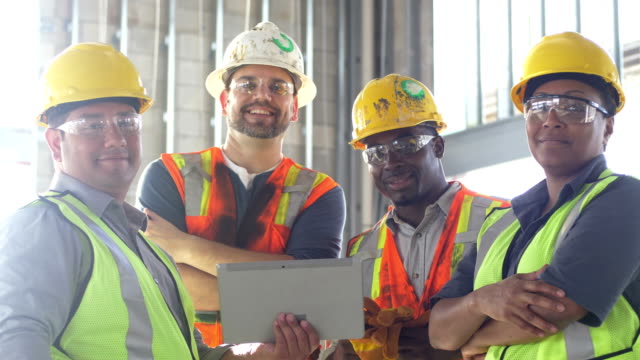 Group of construction workers looking at digital tablet