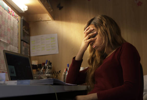 Young woman student covers eyes near computer She is overwhelmed head in hands photos stock pictures, royalty-free photos & images
