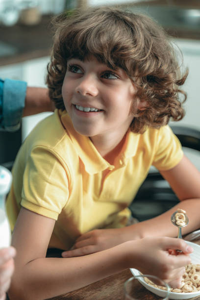 istock Little kid eating cereal breakfast at home 1169808596