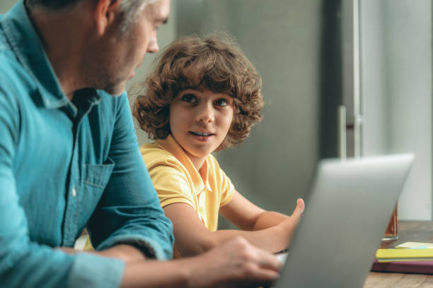 istock Mature father and son making homework, using laptop 1169808824