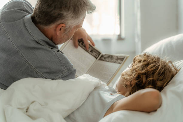 istock Father reading book with son in morning 1169810154