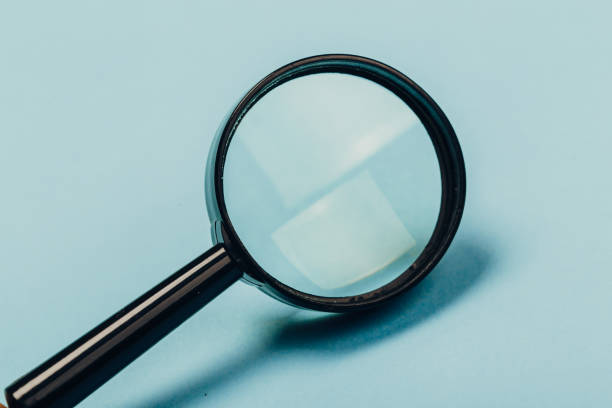 istock Small magnifying glass on pastel blue background, search symbol 1169810982