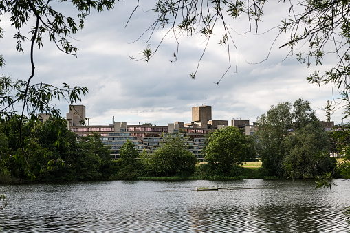 Campus of the University of East Anglia as seen from Earlham Park and lake in the outskirts of Norwich on a cloudy day, England.