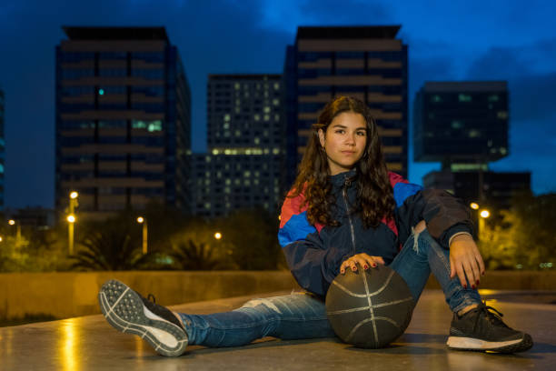 istock Cool young girl sitting with a basket ball 1169811171