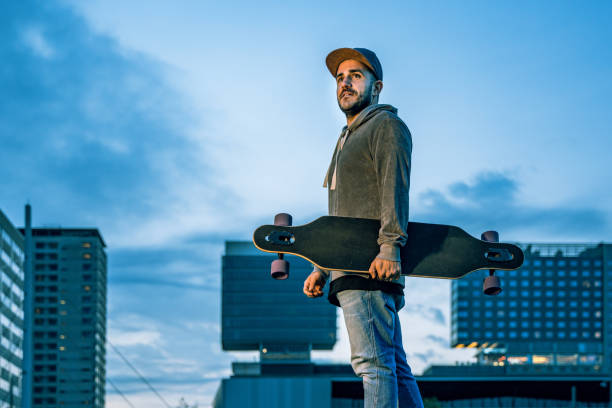 istock Casual man walking with his longboard in Barcelona 1169811827