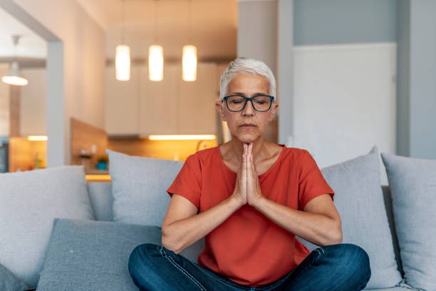 istock Senior woman sitting cross legged, meditating 1169812868