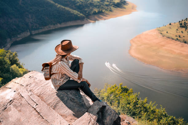 Back to Nature. Woman Solo traveler Day Dreaming. Being high up and looking down. stock photo