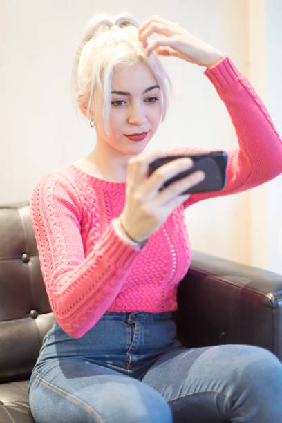 istock Young woman preparing for selfie- checking make up 1169820836