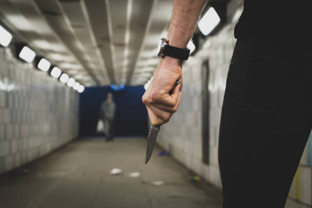 Crime robbery concept. A robber or a killer person with a sharp knife about to commit a homicide in a tunnel Crime robbery concept. A robber or a killer person with a sharp knife about to commit a homicide in a tunnel. knife weapon photos stock pictures, royalty-free photos & images