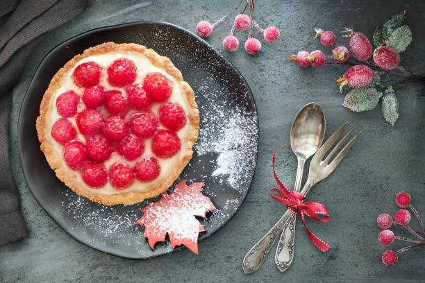 hausgemachte torte mit pudding und frischen himbeeren, serviert auf schwarzem teller mit zucker bestreut - raspberry table wood autumn stock-fotos und bilder