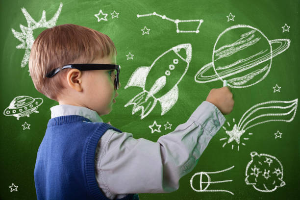 istock Little boy drawing on green blackboard 1169832629