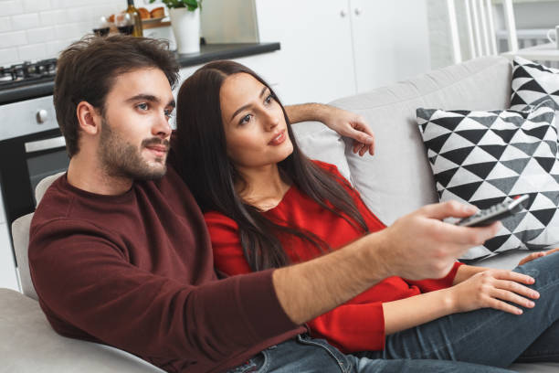 istock Young couple having romantic evening at home watching movie 1169834823