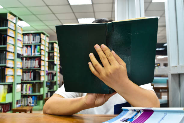 istock Asia woman reading book in library 1169841011
