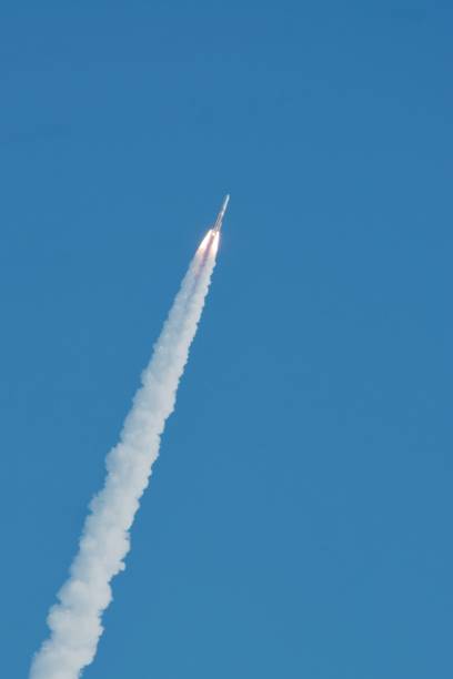 A rocket launches into the blue sky stock photo