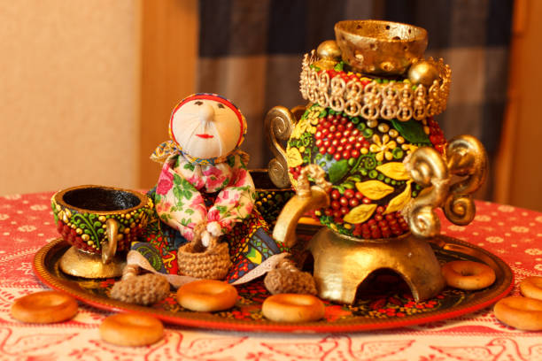 Handmade gingerbread samovar and tea cups standing on a table on a dish.