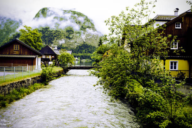 Morning mist over embankment in the Austrian village Hallstatt.  Rain and clouds in rural Austria. Retro style