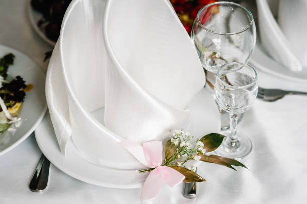 istock Serving, setting table. Plate with silverware cutlery, linen napkin are decorated with gold branch greens. Wedding table decoration. Close up. 1169855297