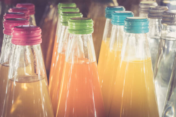 Rows of Colourful Glass Bottles of Drink Lined Up in Fridge at Cafe