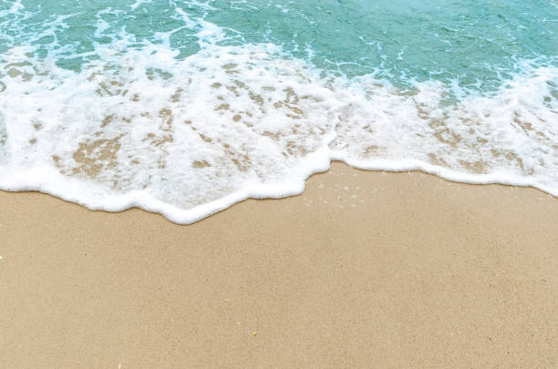 istock Light blue ocean waves on the background sand beach 1169858497