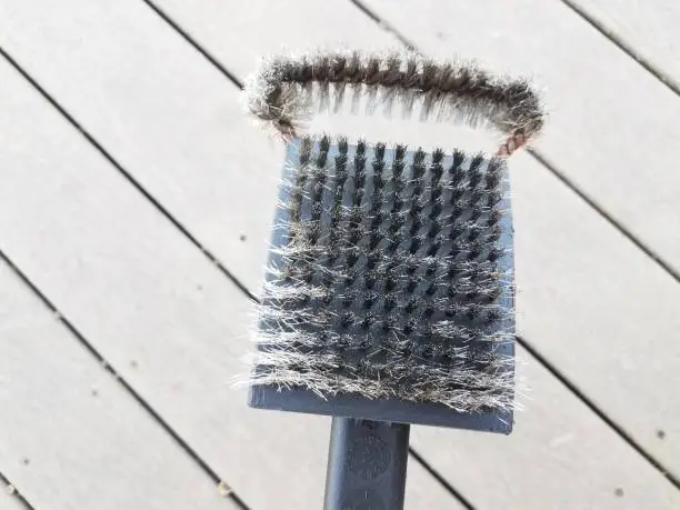 Photo of black metal wire brush to clean barbeque grill and wood