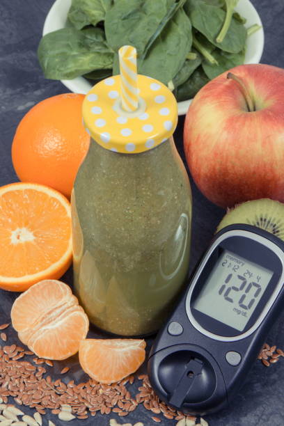 istock Glucometer for checking sugar level and freshly blended coctail from fruits and vegetables, diabetes and healthy dessert containing vitamins concept 1169863604