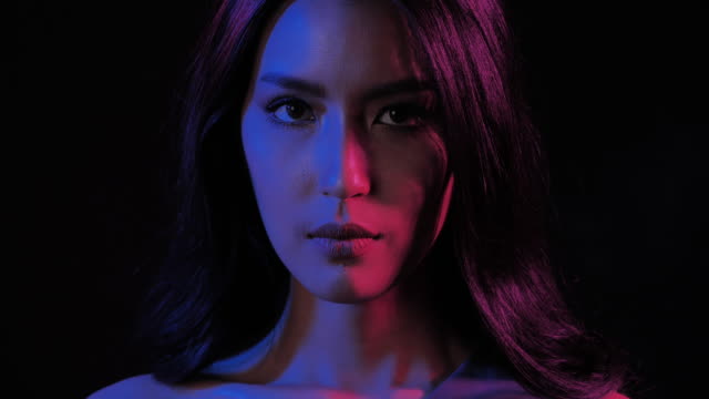 Fantastic video of sexy portrait of beautiful and sexy woman on black background under UV black light.Expressive facial expressions.Cosmetology and Spa.Beauty Face.Video: Diverse Portraits,Party concept