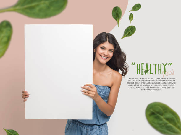 istock Smiling young woman holding blank placard 1169868096