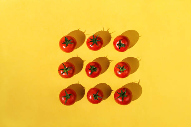 istock Flatlay of fresh red ripe tomatoes arranged on yellow background 1169868403