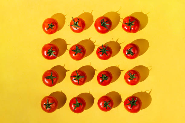 istock Flatlay of fresh red ripe tomatoes arranged on yellow background 1169868405