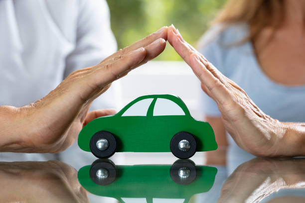 istock Couple Protecting Green Wooden Car 1169870502