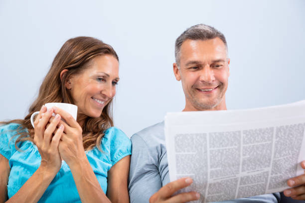 istock Couple Reading Newspaper At Home 1169871476