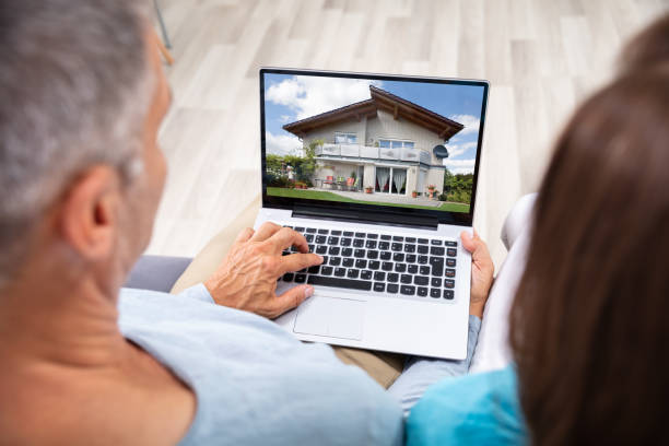 Couple Looking At House Couple Looking At House Online On Laptop At Home selling photos stock pictures, royalty-free photos & images