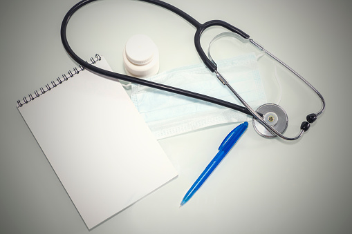 Stethoscope in the office of doctors.Top view of doctor's desk table, blank paper on clipboard with pen. Copy space