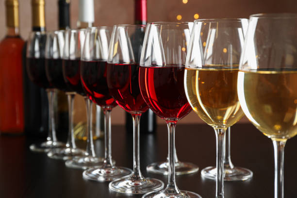 istock Bottles and glasses with wine on dark table, blurred lights, closeup 1169874659