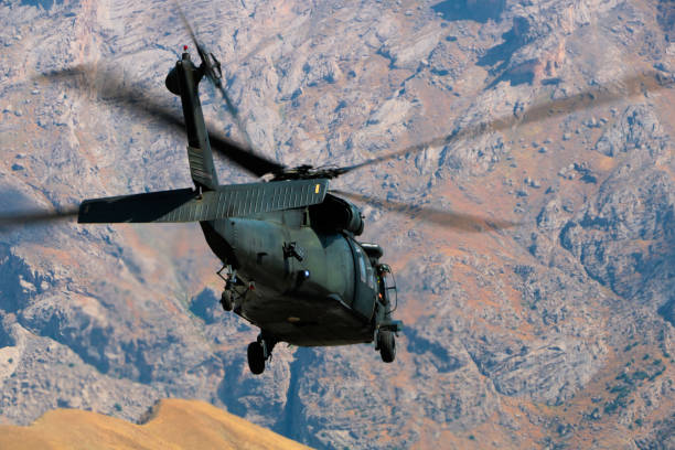 istock Military Utility Helicopter flying against mountain 1169874793