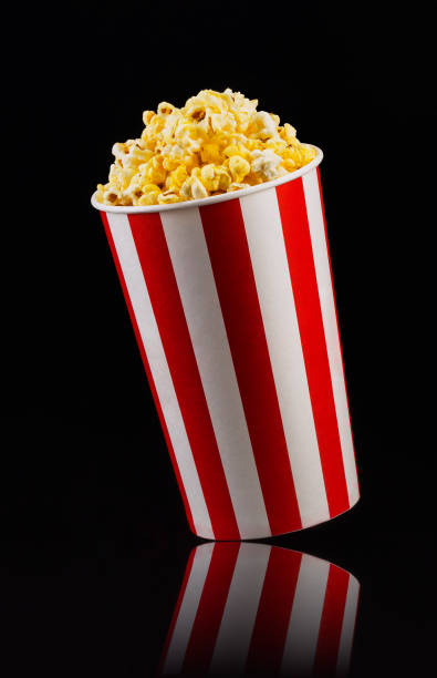 istock Paper striped bucket with popcorn isolated on black background 1169875913