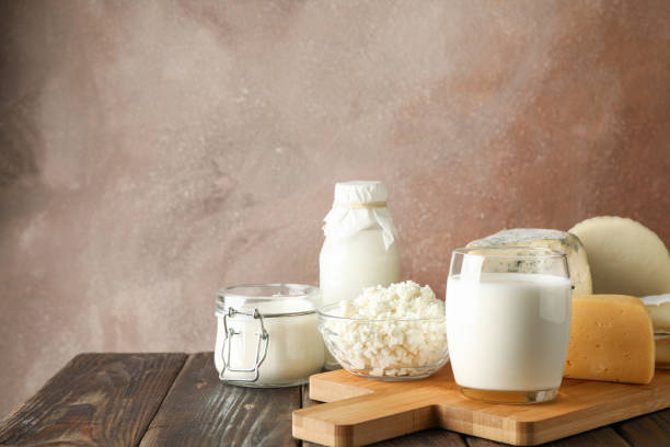 istock Fresh dairy products and cutting board on wooden background, copy space 1169880048