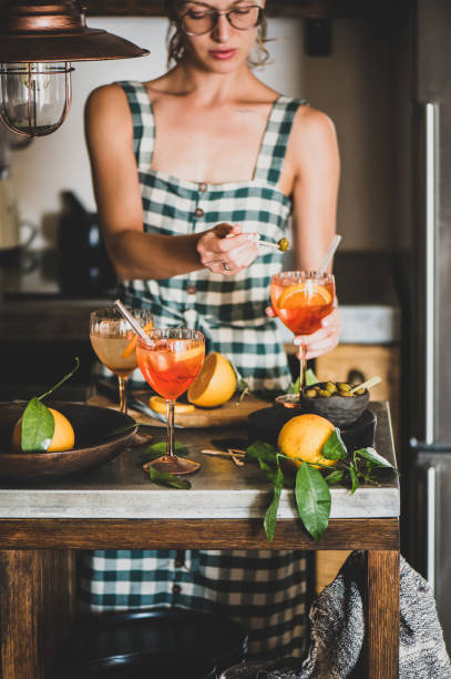 mujer joven sosteniendo aperol spritz cóctel y oliva - women food smiling serving size fotografías e imágenes de stock