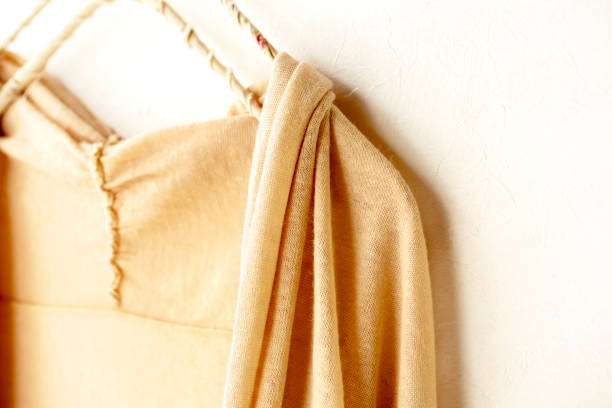 istock a cardigan in beige hanging on clothes hanger on white background. 1169899512
