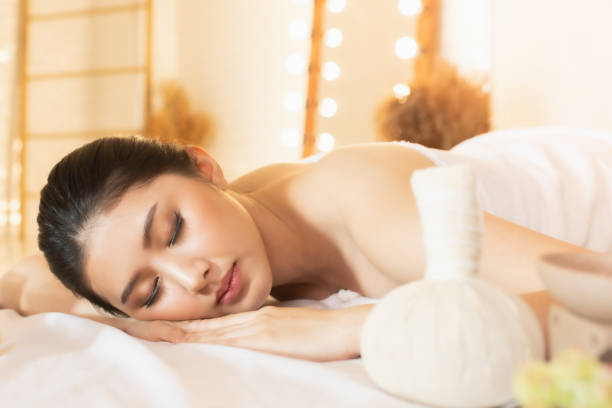 femme asiatique belle, jeune et saine dans le salon de spa. salle de spa de traitement de massage. médecine traditionnelle et concept de guérison. - endormissement spa photos et images de collection