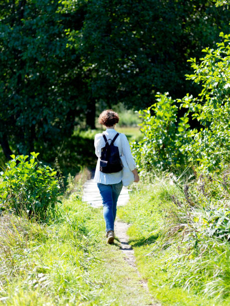 istock Woman walking on the footpath 1169900460
