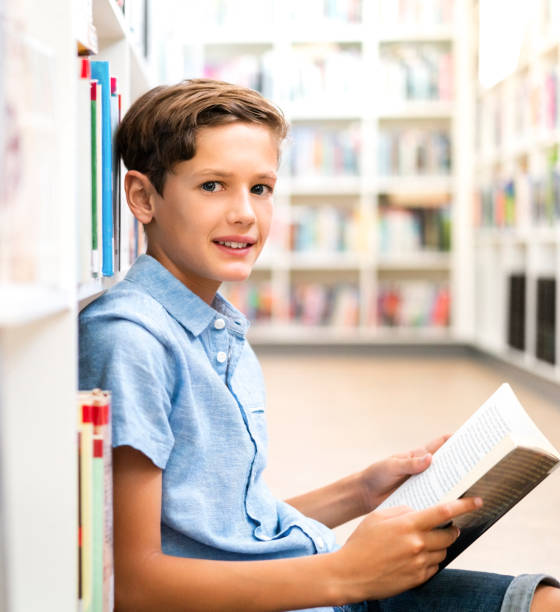 istock Portrait of schoolboy studying in library 1169906561