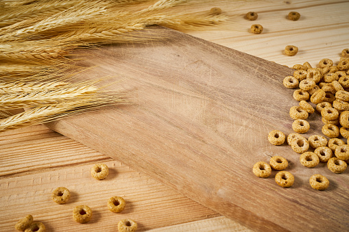 wooden background with yellow ears of rye and breakfast crunchy