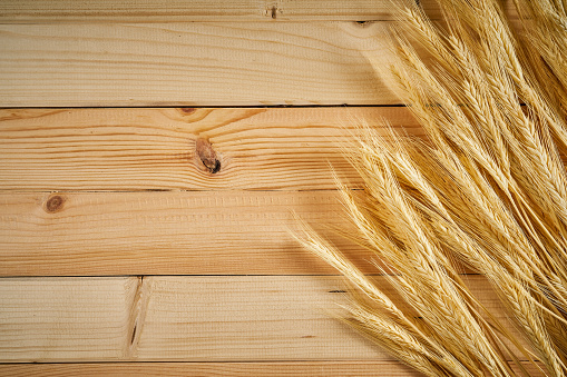 wooden background with yellow ears of rye