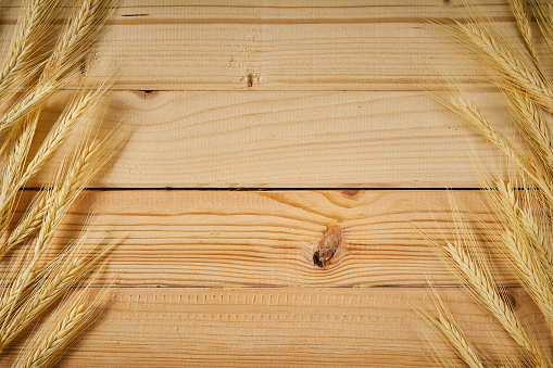 wooden background with yellow ears of rye