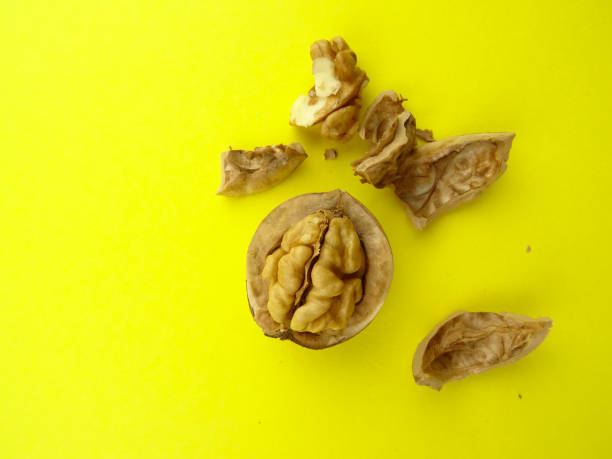 istock Cracked Walnut isolated on a yellow background 1169912464