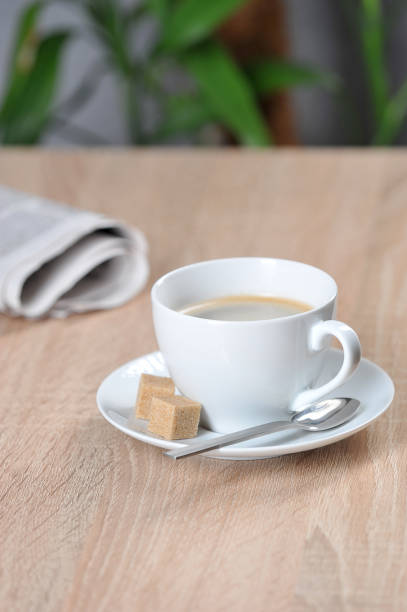 istock A cup of coffee and a newspaper on a table in a cafe.  Free space for text. 1169913841