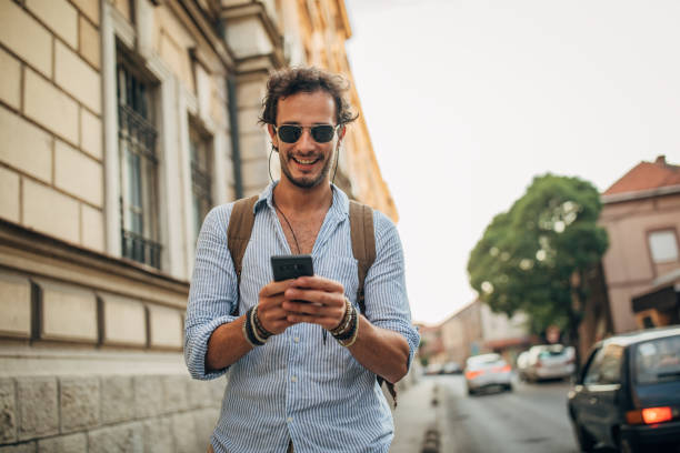 istock Charming man using phone on the street 1169913972