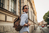Charming man with backpack in city