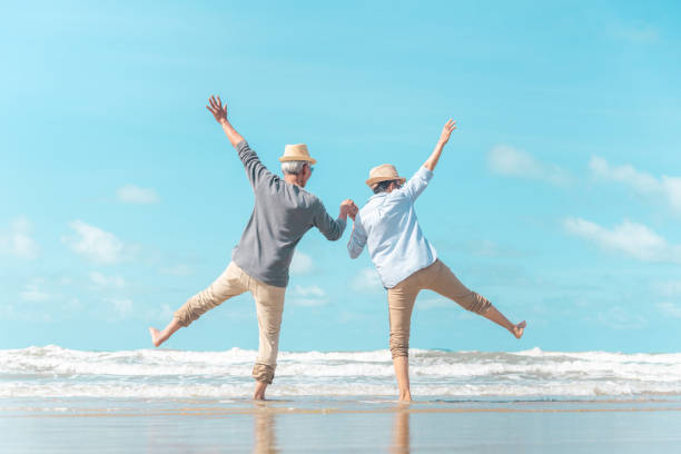charmantes älteres paar ging an den strand, um die meeresbrise zu genießen - dancing couple happiness heterosexual couple stock-fotos und bilder